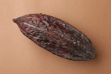 Cocoa pod on brown background, top view