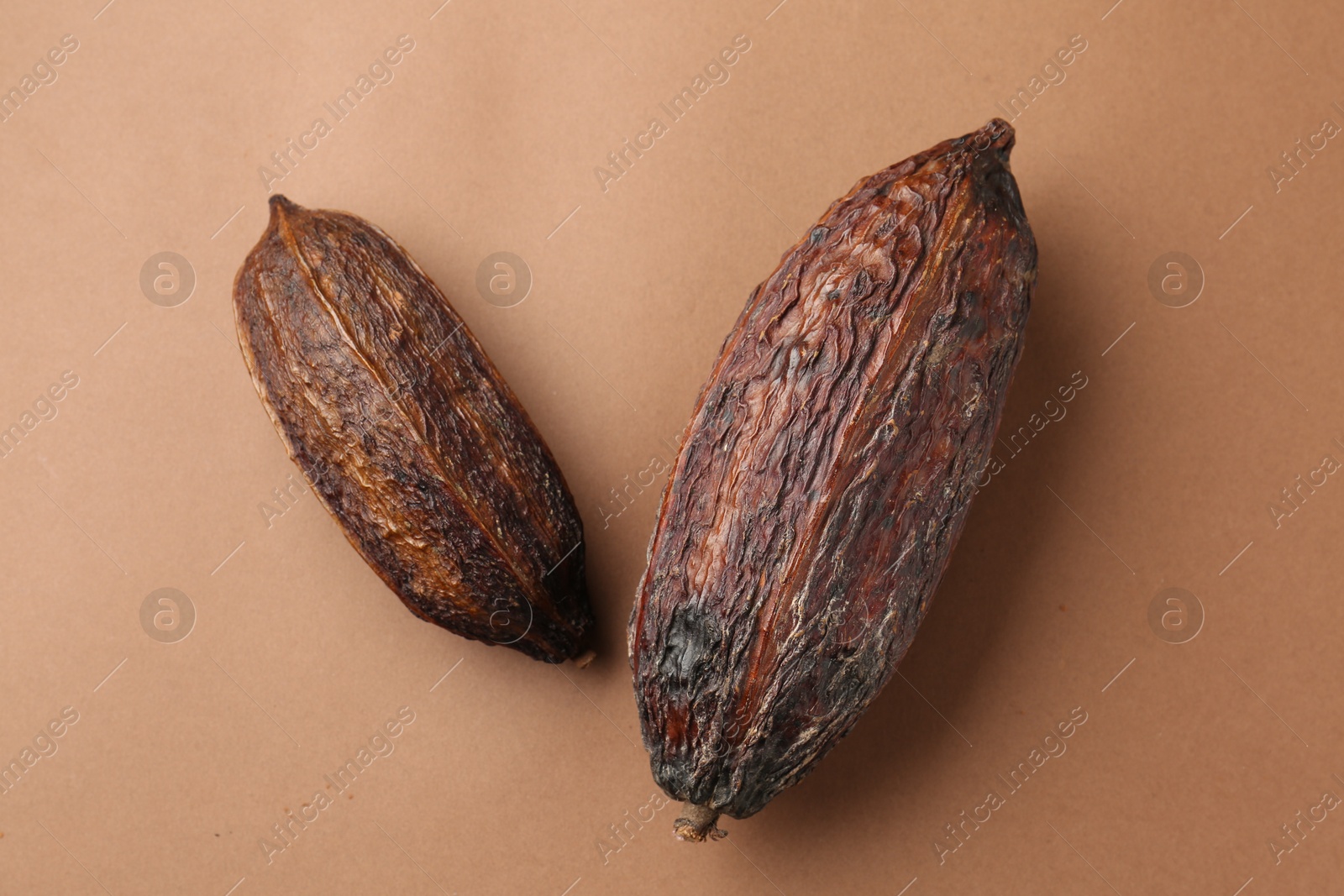 Photo of Cocoa pods on brown background, top view