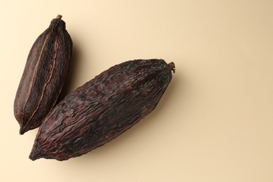 Photo of Cocoa pods on beige background, top view. Space for text