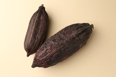 Photo of Cocoa pods on beige background, top view