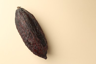 Photo of Cocoa pod on beige background, top view. Space for text