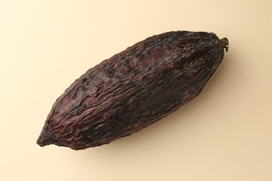 Photo of Cocoa pod on beige background, top view