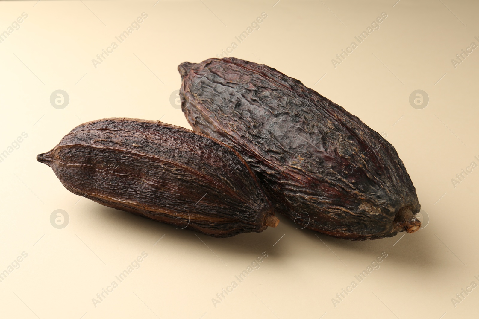 Photo of Whole tropical cocoa pods on beige background