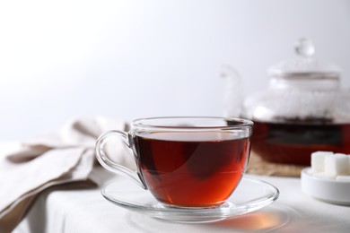 Photo of Refreshing black tea in cup on light table