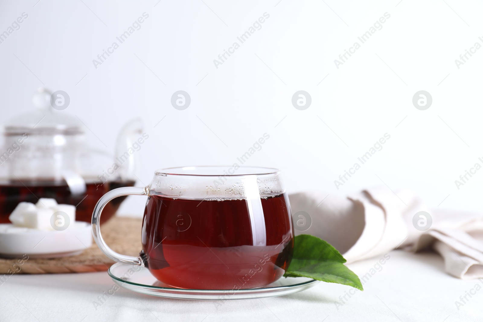 Photo of Refreshing black tea in cup on light table