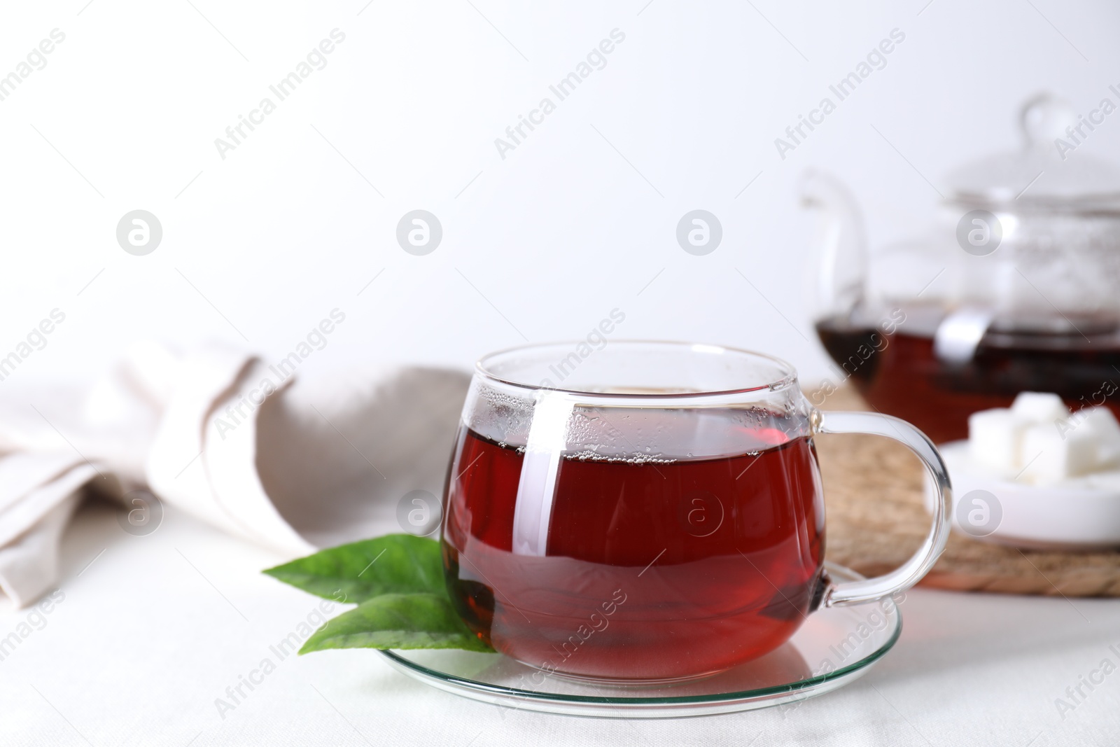 Photo of Refreshing black tea in cup on light table