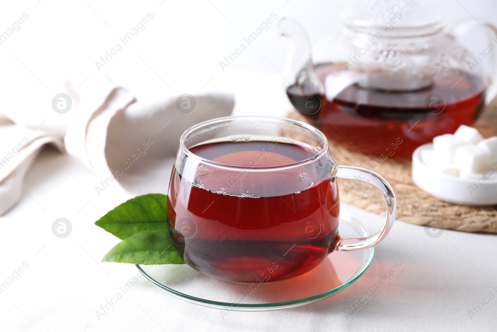 Photo of Refreshing black tea in cup on light table