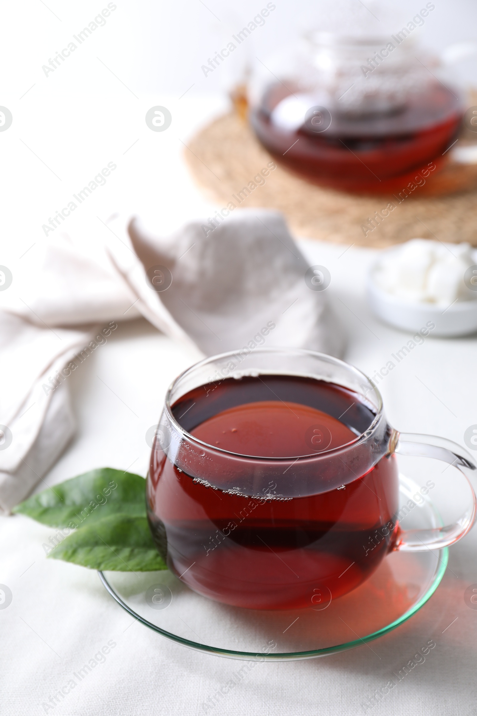 Photo of Refreshing black tea in cup on light table