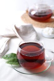 Photo of Refreshing black tea in cup on light table