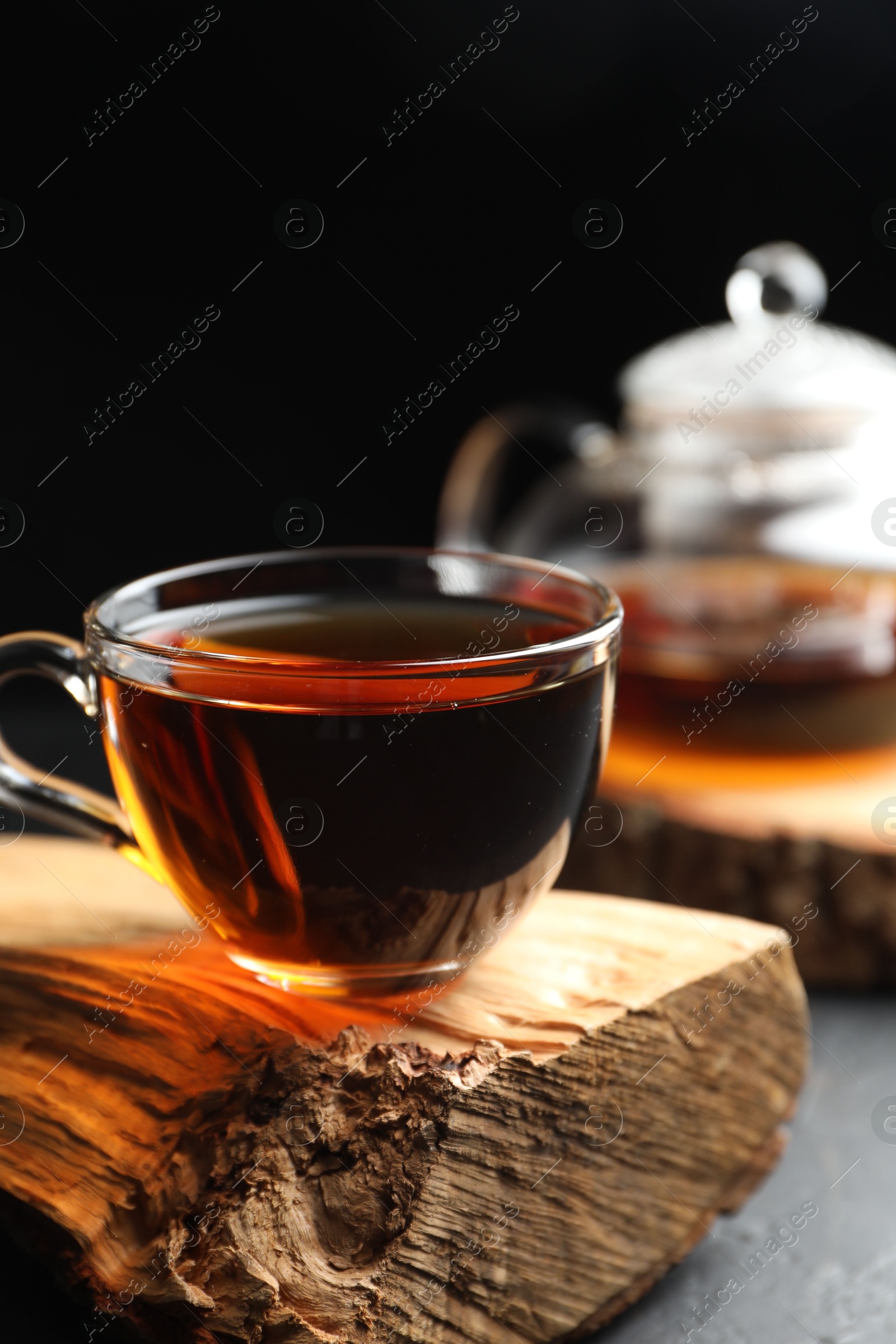 Photo of Aromatic black tea in cup on grey table, closeup