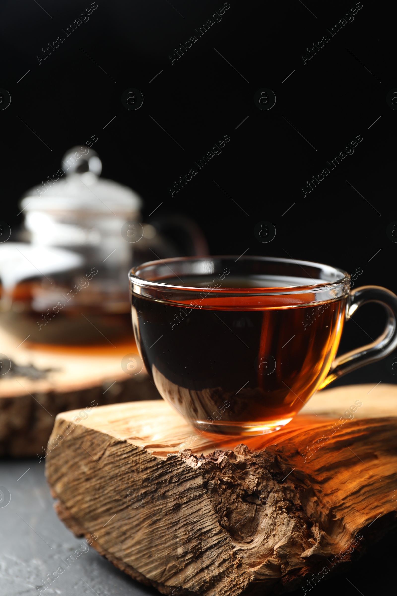 Photo of Aromatic black tea in cup on grey table, closeup