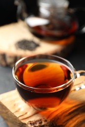 Photo of Aromatic black tea in cup on table, closeup