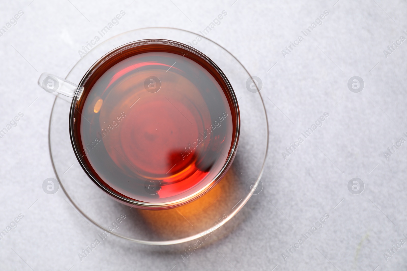 Photo of Aromatic black tea in cup on light table, top view. Space for text