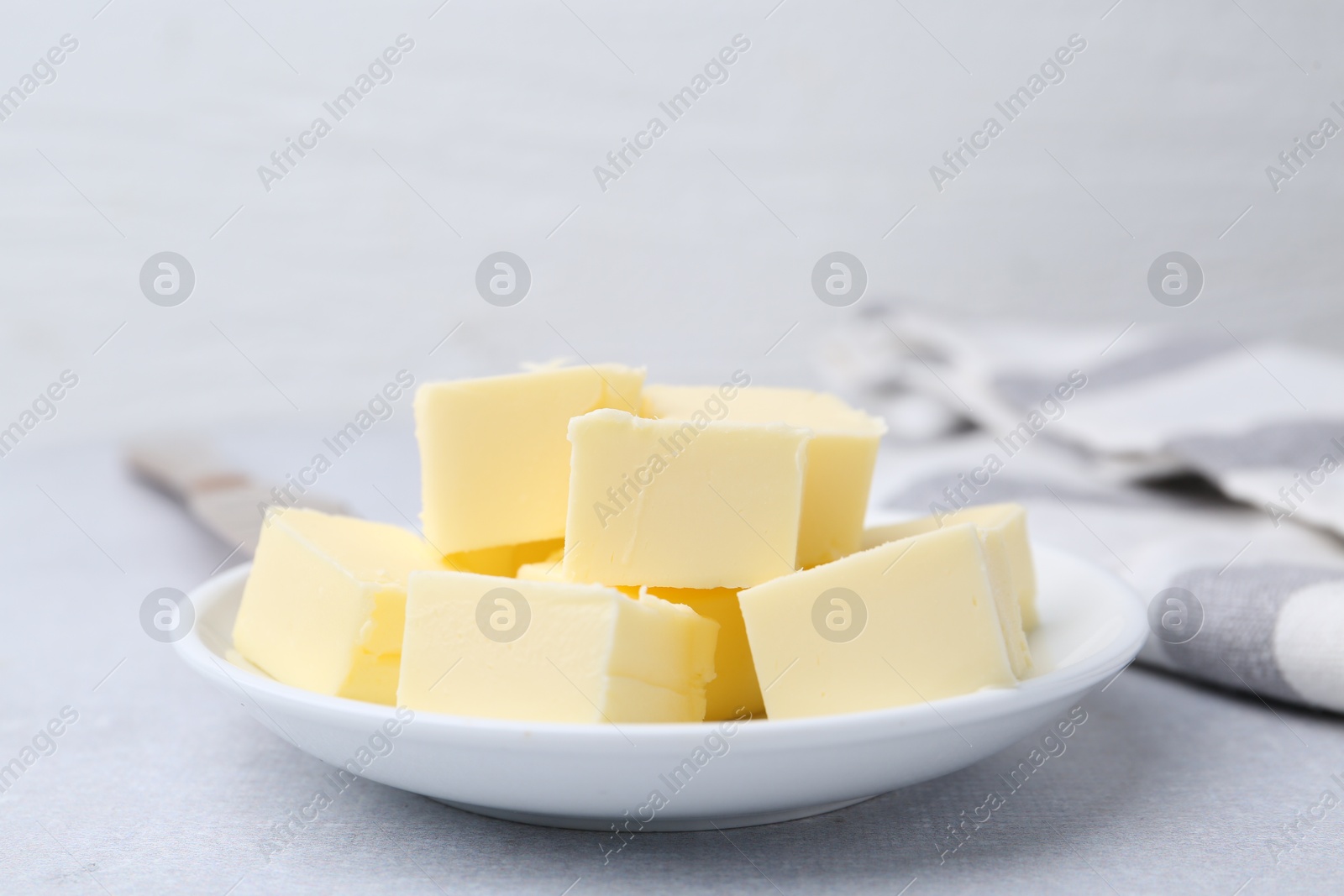 Photo of Pieces of fresh butter on white table, closeup