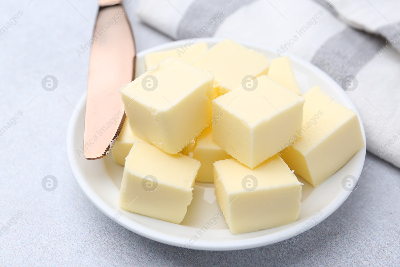 Photo of Pieces of fresh butter on white table, closeup