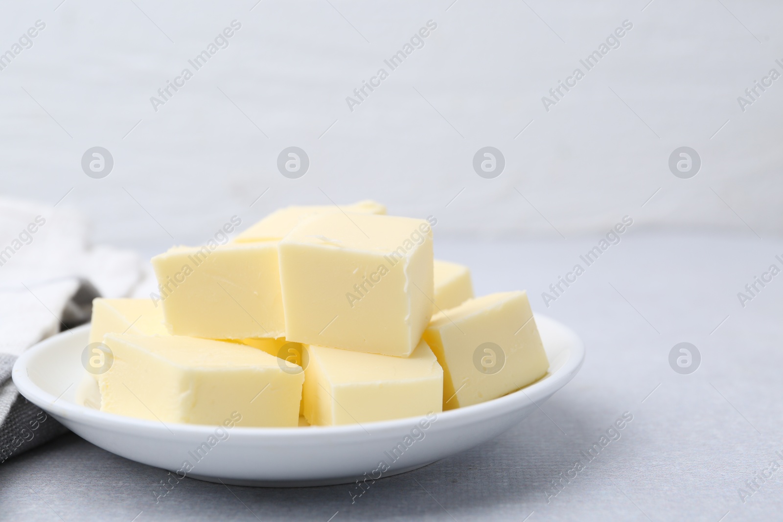 Photo of Pieces of fresh butter on white table, closeup