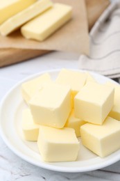 Pieces of fresh butter on white textured table, closeup