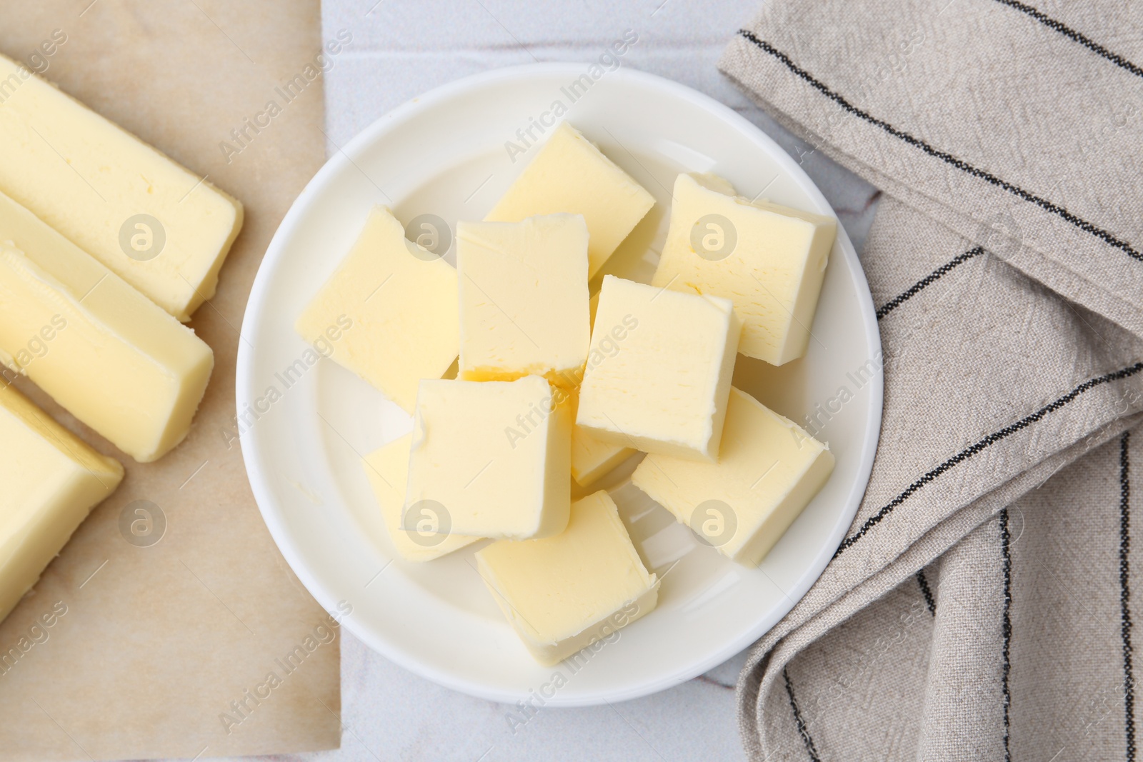 Photo of Pieces of fresh butter on white textured table, top view