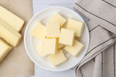 Photo of Pieces of fresh butter on white textured table, top view