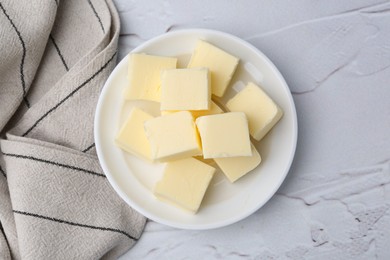 Photo of Pieces of fresh butter on white textured table, top view