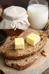 Photo of Slices of bread with butter, honey and milk on table, closeup