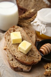 Photo of Slices of bread with butter, honey, milk and walnuts on table, closeup