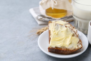 Photo of Slices of bread with butter, honey and milk on light grey table, closeup. Space for text