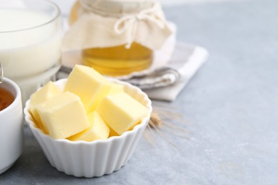 Photo of Fresh butter, honey and milk on light grey table, closeup. Space for text