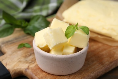 Pieces of butter on wooden board, closeup