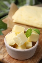 Photo of Pieces of butter on wooden board, closeup