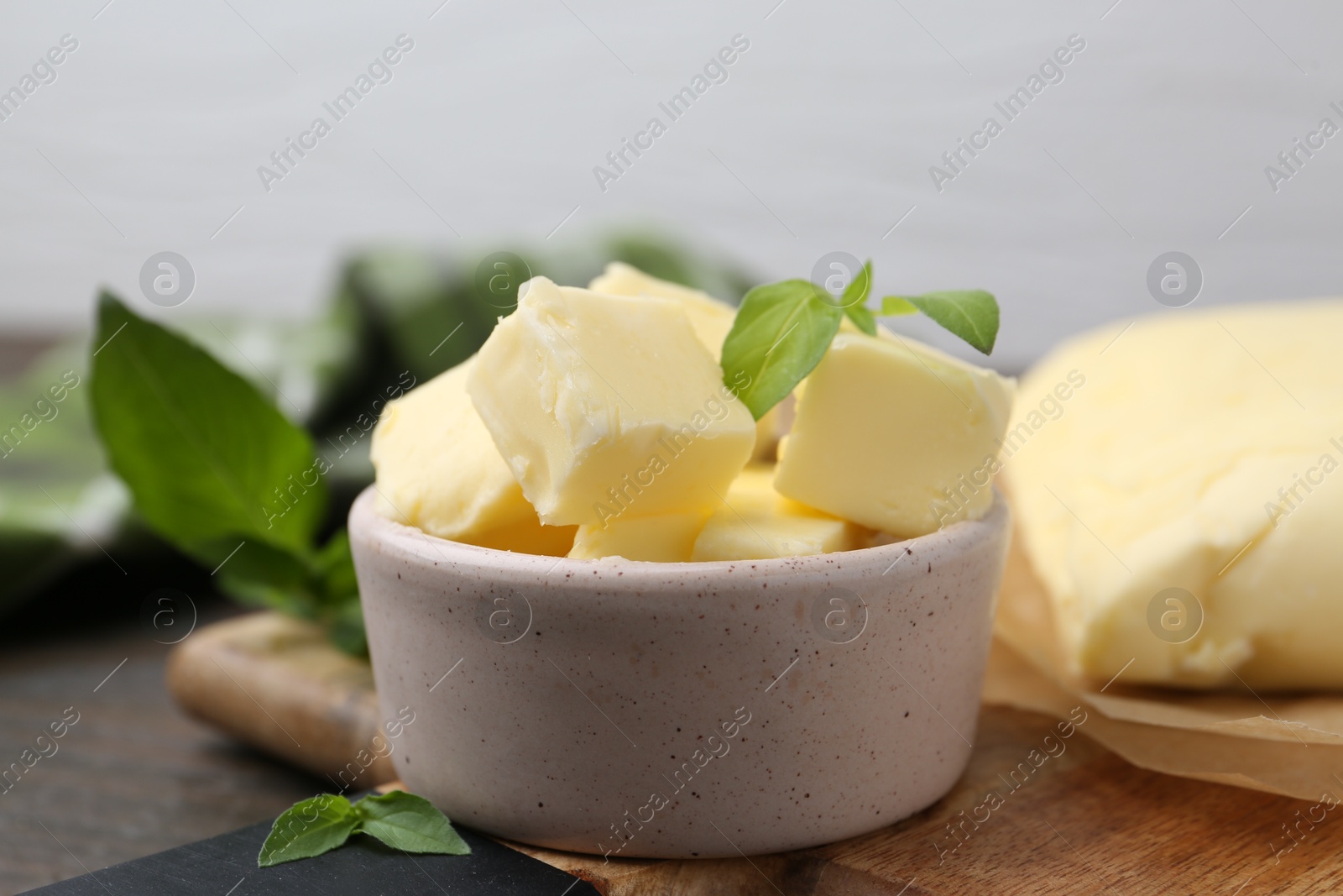 Photo of Pieces of butter on wooden table, closeup