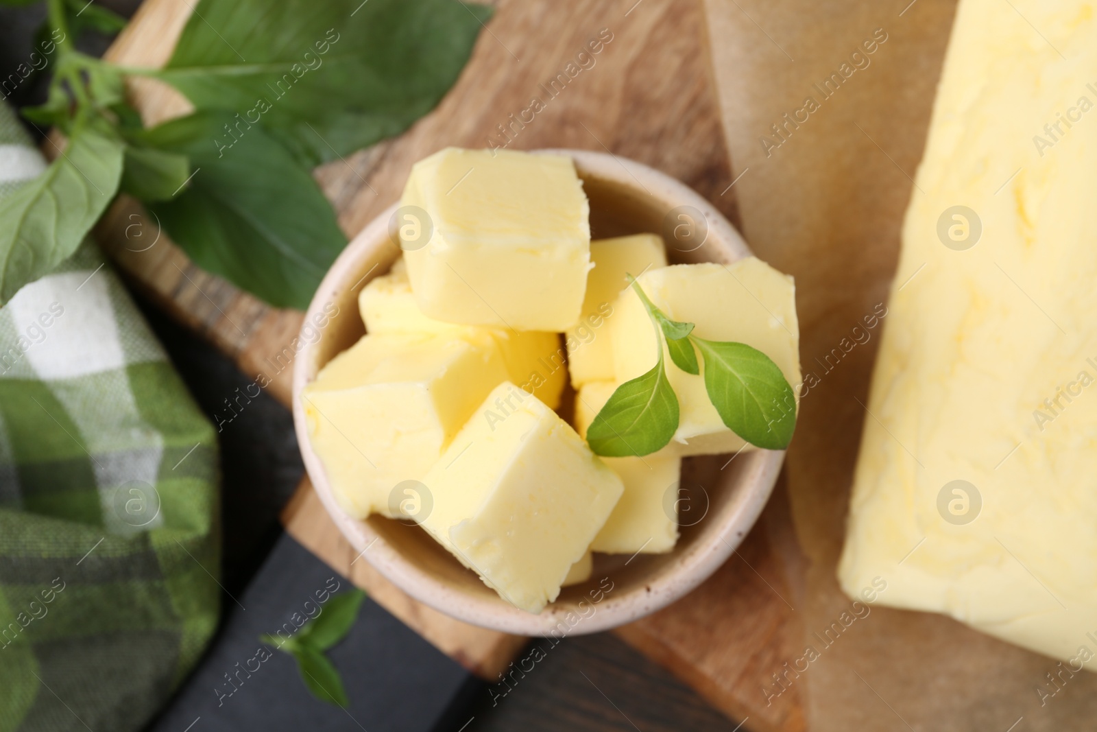 Photo of Pieces of butter on wooden board, top view