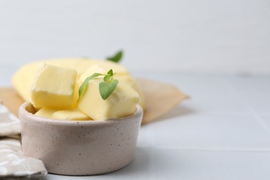 Photo of Pieces of butter on white tiled table, closeup. Space for text