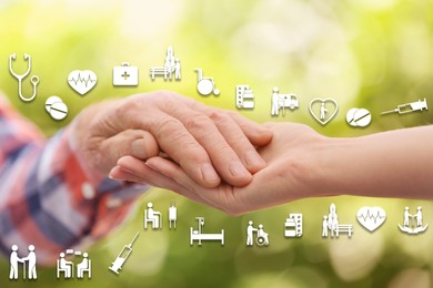 Image of Caregiver and elderly man against blurred background, closeup of hands. Healthcare icons