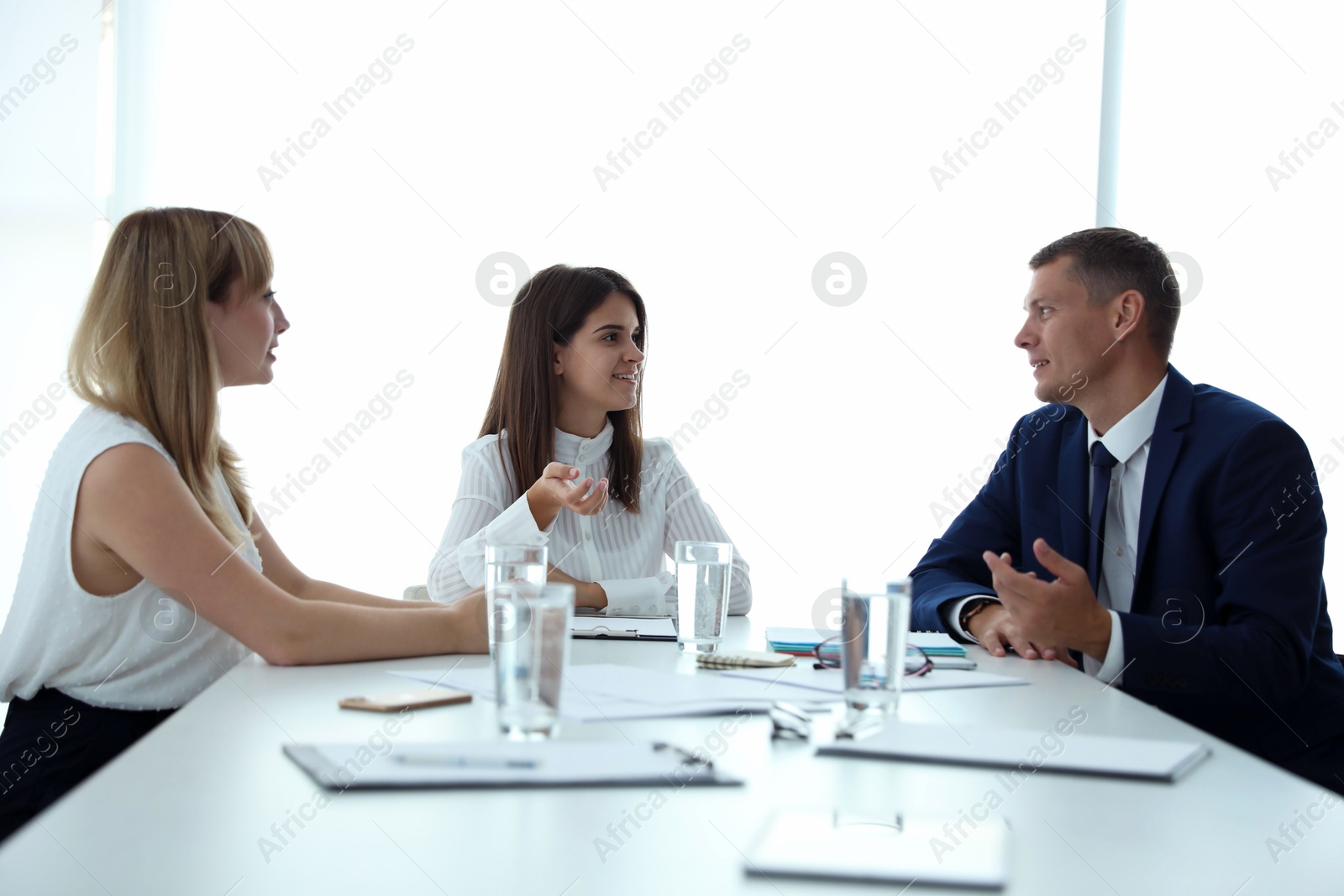 Photo of Office employees talking at table during meeting