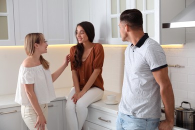 Group of people having conversation in kitchen