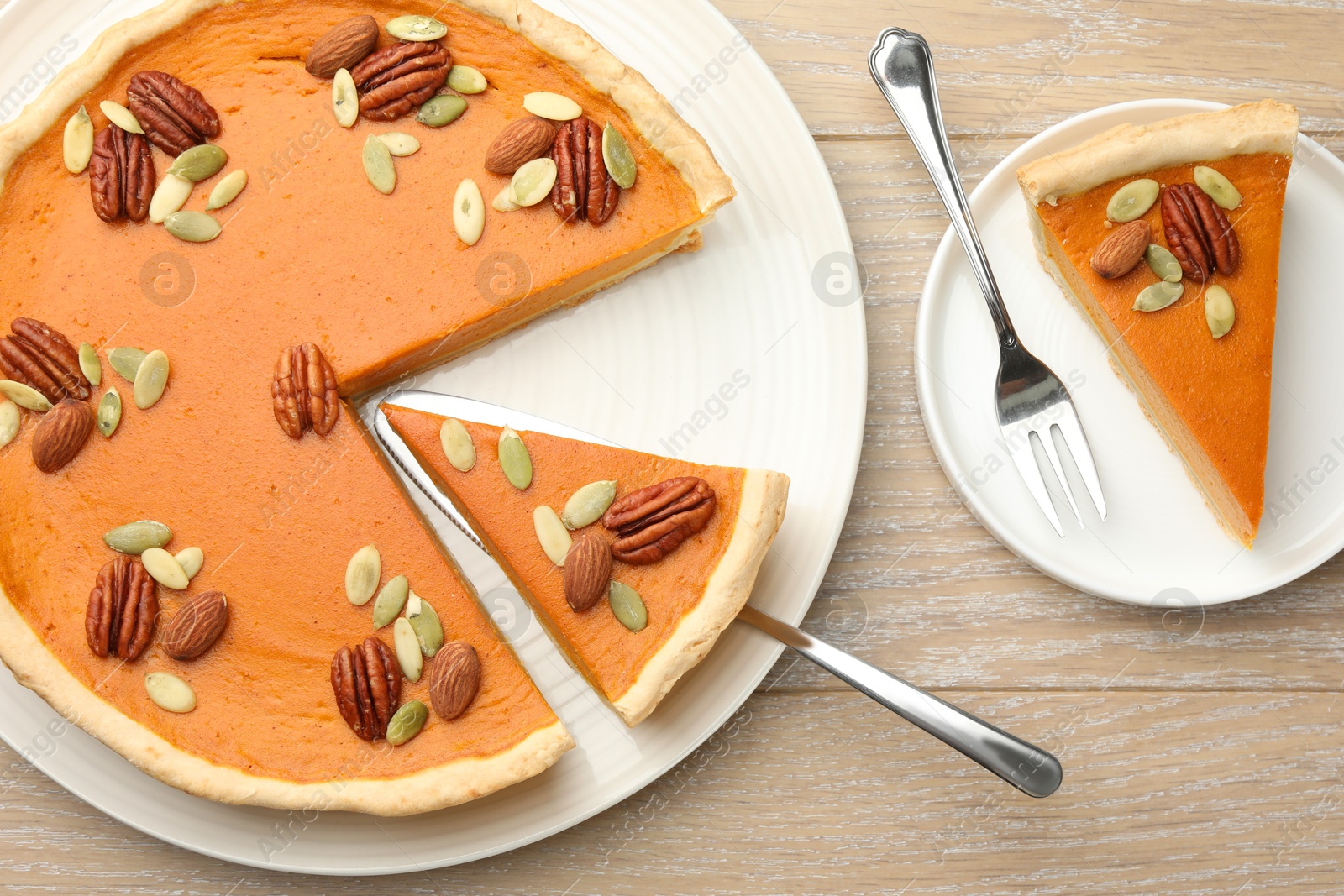 Photo of Tasty homemade pumpkin pie served on wooden table, top view