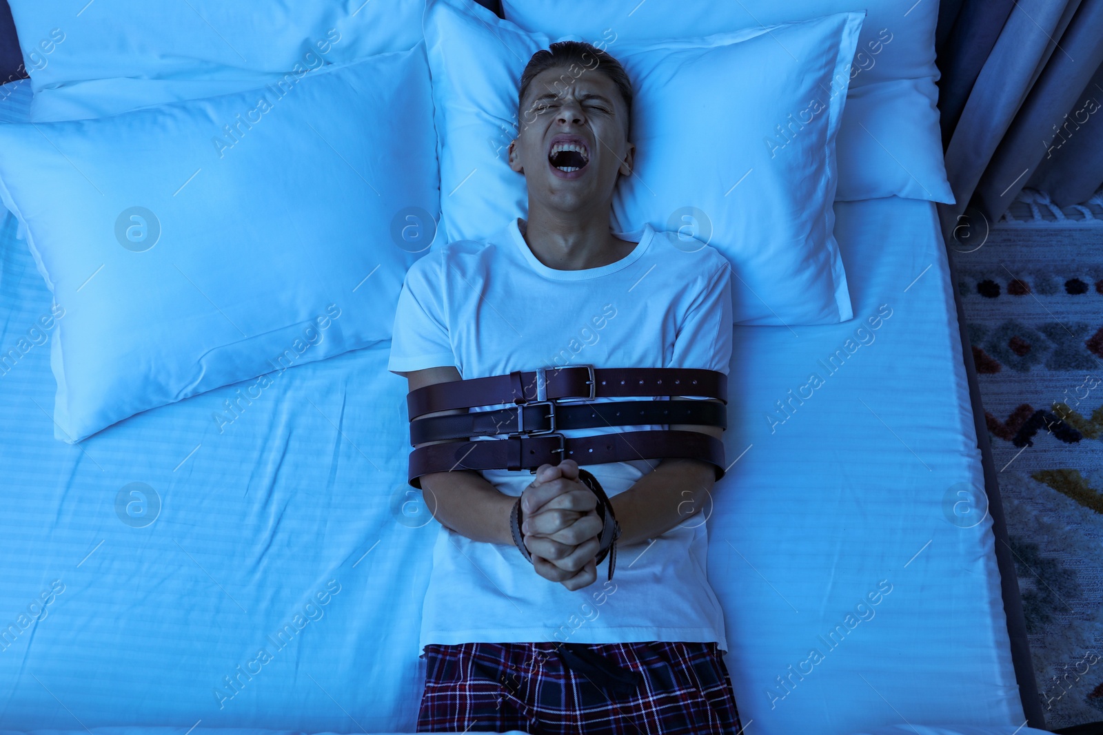 Photo of Man in sleepwalking condition screaming on bed, above view