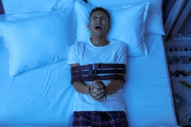 Photo of Man in sleepwalking condition screaming on bed, above view