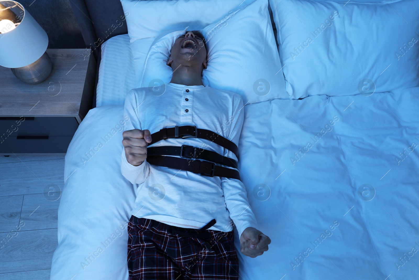 Photo of Man in sleepwalking condition screaming on bed, above view