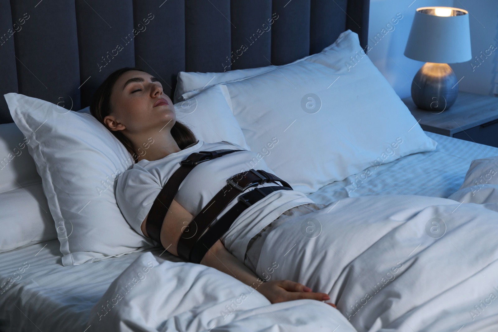 Photo of Sleepwalker fastened with belts lying in bed