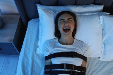 Photo of Woman in sleepwalking condition screaming on bed, top view