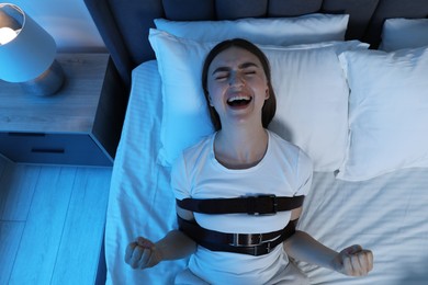 Woman in sleepwalking condition screaming on bed, top view