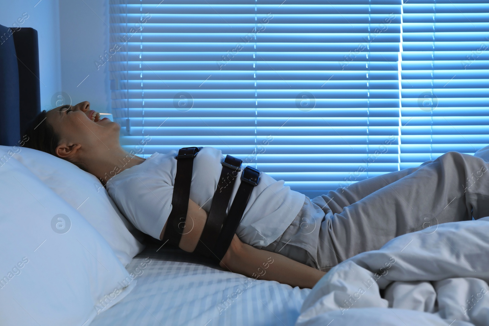 Photo of Woman in sleepwalking condition screaming on bed