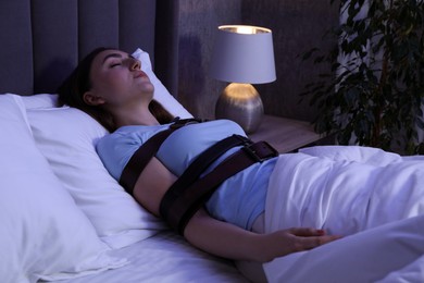 Photo of Sleepwalker fastened with belts lying in bed