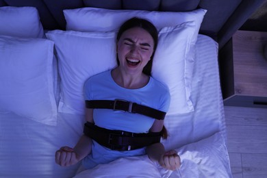 Photo of Woman in sleepwalking condition screaming on bed, top view