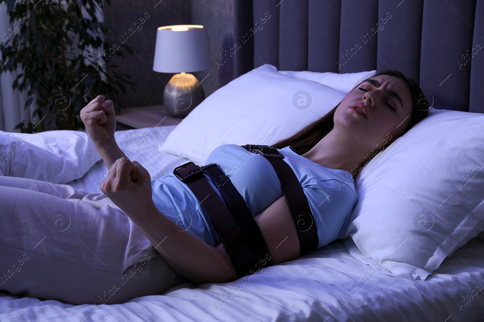 Photo of Sleepwalker fastened with belts lying on bed