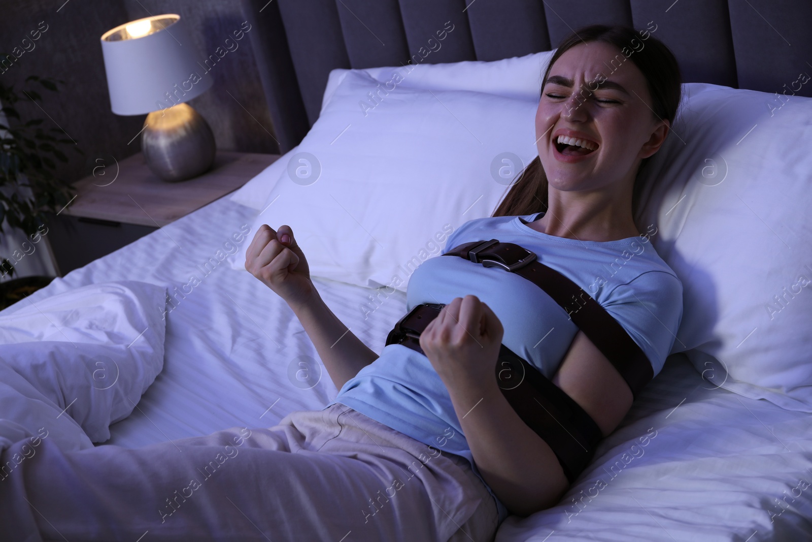 Photo of Woman in sleepwalking condition screaming on bed