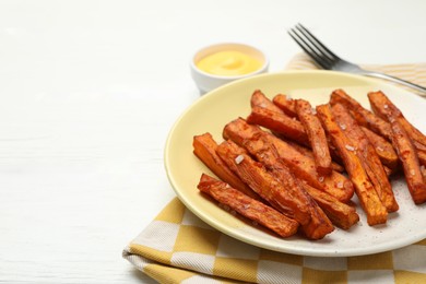 Photo of Delicious sweet potato fries and sauce on white wooden table, closeup. Space for text