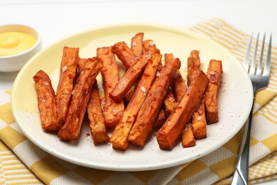 Photo of Delicious sweet potato fries and sauce on table, closeup